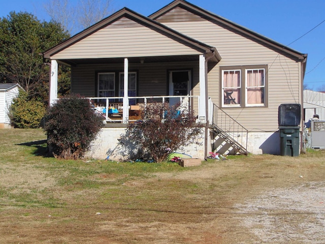 bungalow-style home with covered porch and a front lawn