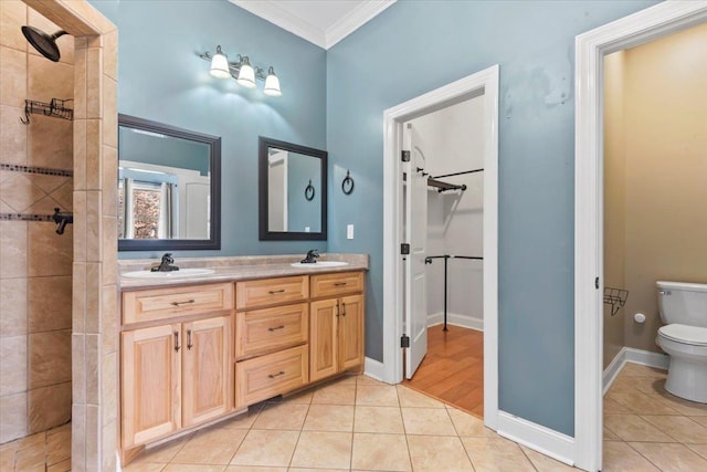 bathroom featuring tiled shower, ornamental molding, toilet, tile patterned floors, and vanity