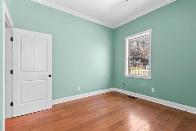 empty room with wood-type flooring and ornamental molding