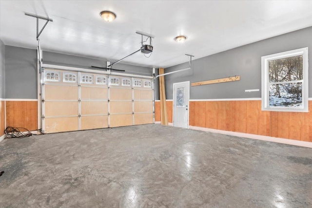 garage featuring a garage door opener and wood walls