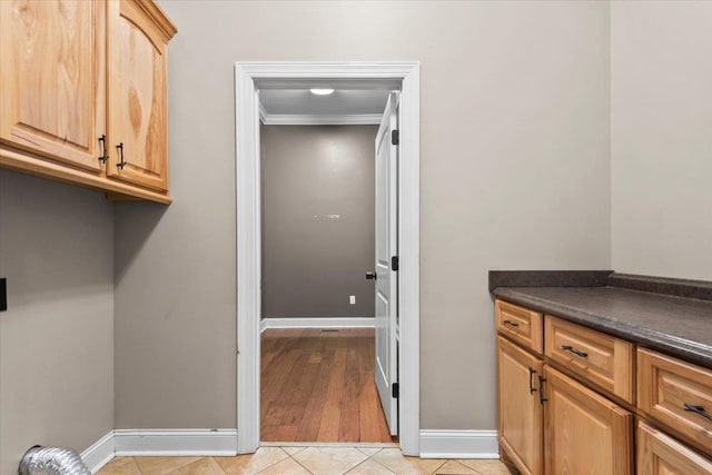 laundry room with ornamental molding and light tile patterned floors