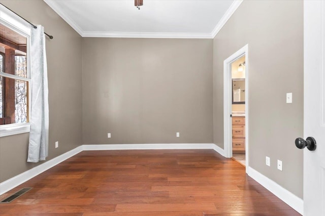 empty room featuring crown molding and dark hardwood / wood-style floors