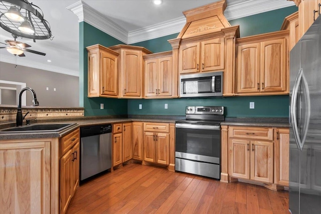 kitchen featuring sink, ornamental molding, ceiling fan, hanging light fixtures, and appliances with stainless steel finishes