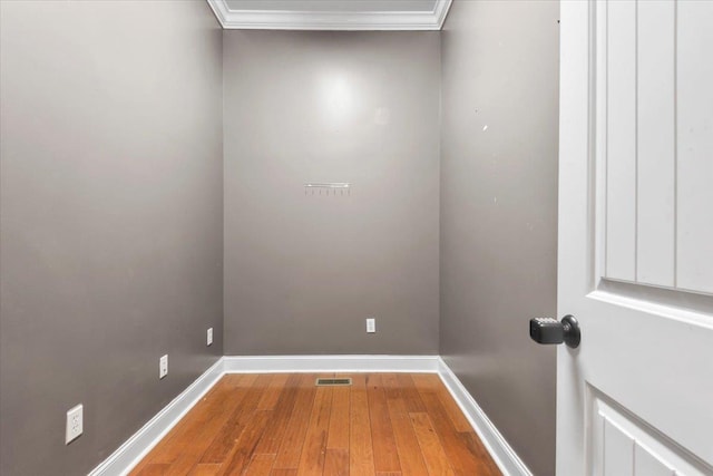 spare room featuring hardwood / wood-style flooring and ornamental molding