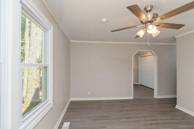 empty room with dark hardwood / wood-style flooring, ceiling fan, and ornamental molding