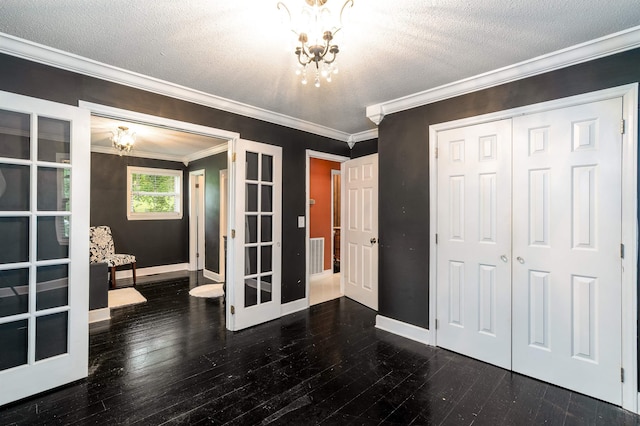  - unfurnished bedroom with a chandelier, crown molding, a closet, dark wood-type flooring, and a textured ceiling