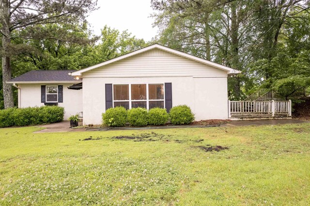  - rear view of property with stucco siding and a lawn