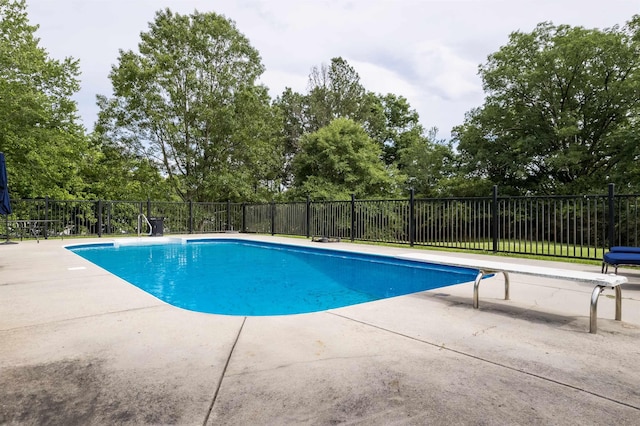  - view of swimming pool with a patio and view of wooded area