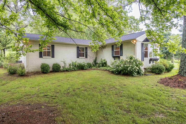  - ranch-style home featuring a front yard, stucco siding, and brick siding