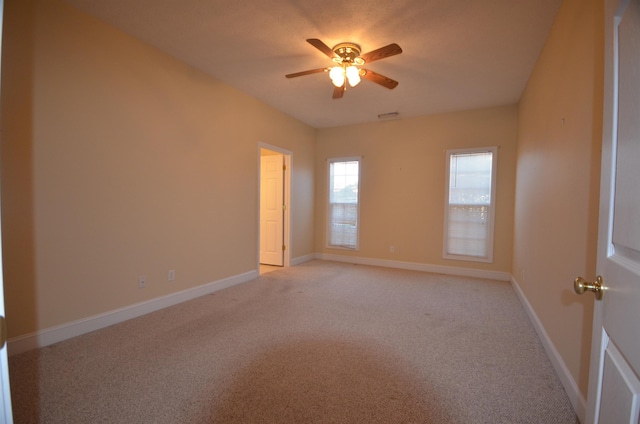 spare room featuring light carpet and ceiling fan