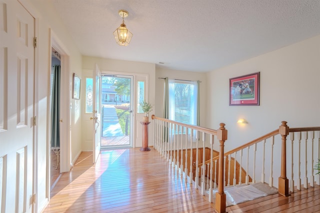 foyer entrance featuring a textured ceiling and light wood finished floors