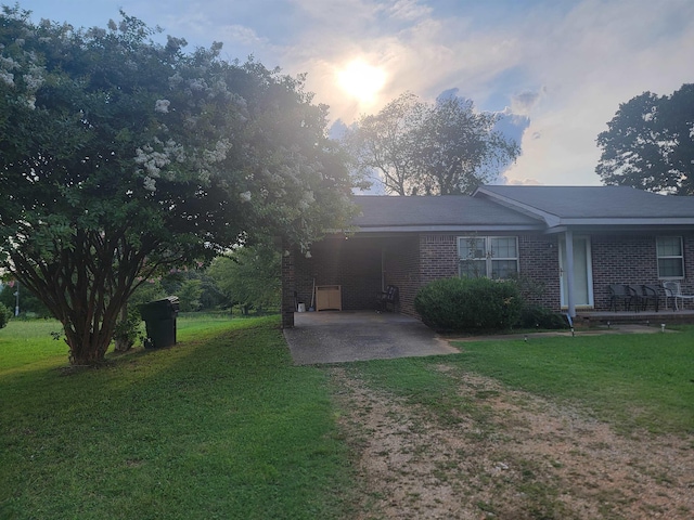 view of front of house featuring a carport and a yard