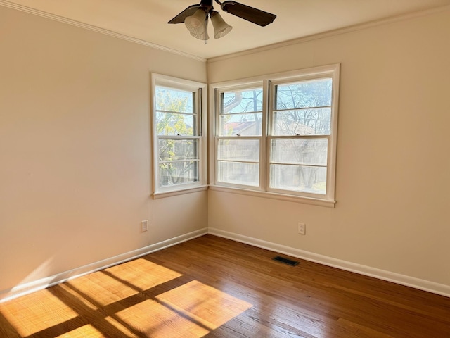 empty room featuring crown molding, ceiling fan, plenty of natural light, and wood-type flooring