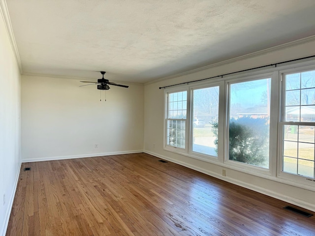 spare room with ornamental molding, hardwood / wood-style floors, ceiling fan, and a textured ceiling