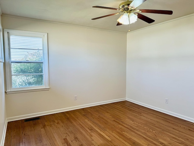 spare room with hardwood / wood-style floors, ornamental molding, and ceiling fan