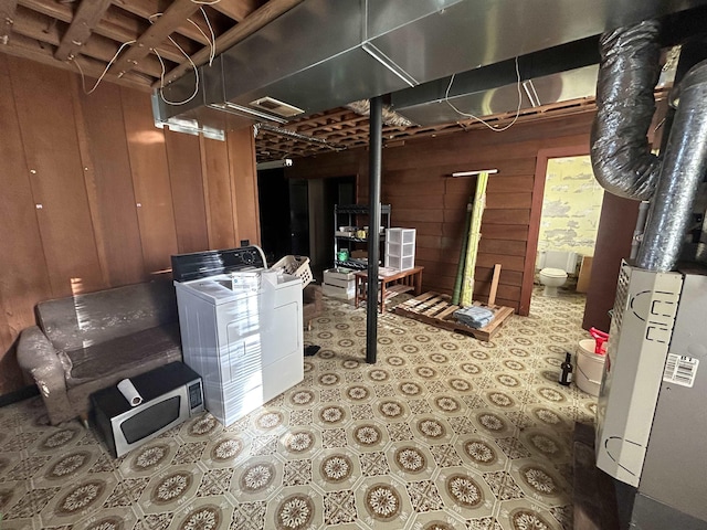 basement with washer and dryer and wood walls