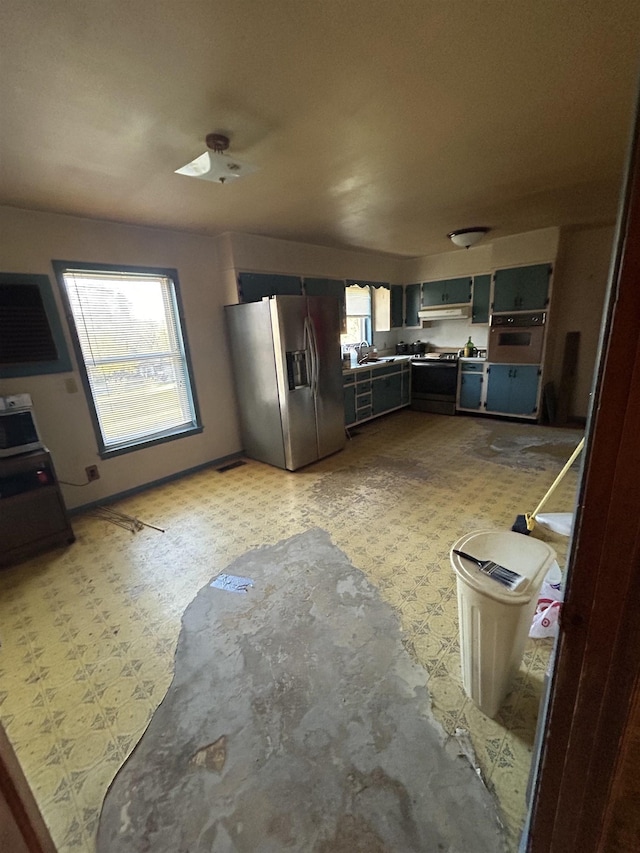 kitchen featuring stainless steel fridge, stove, and sink