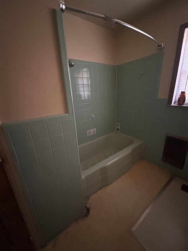 bathroom featuring tiled shower / bath and tile walls