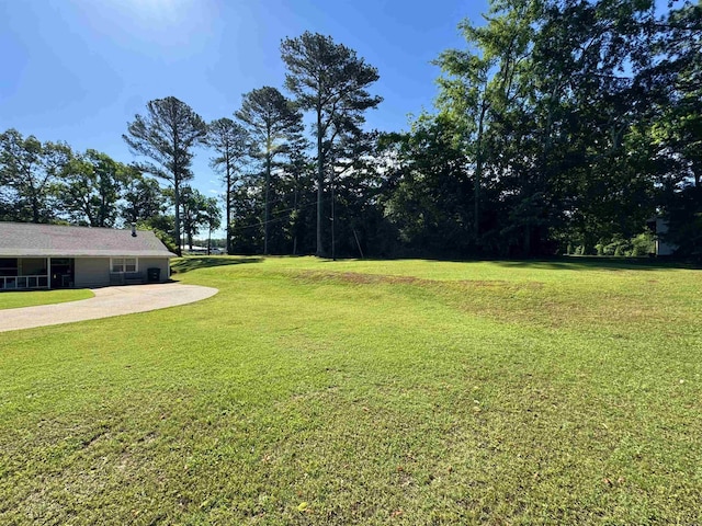  - view of green lawn featuring concrete driveway