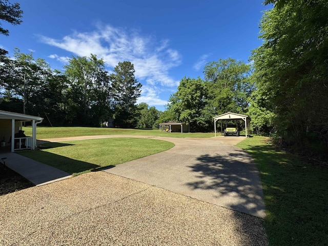  - view of green lawn with driveway and a carport
