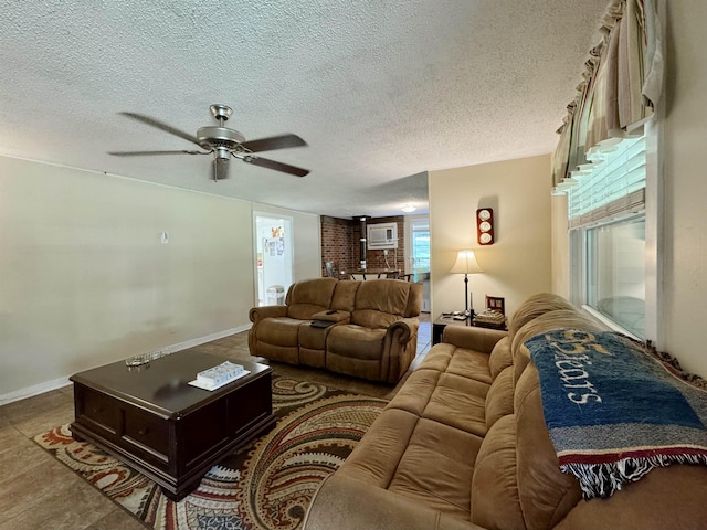  - living area featuring a ceiling fan, a textured ceiling, and baseboards