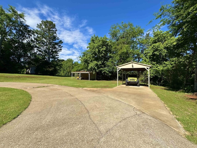  - surrounding community featuring a yard, concrete driveway, and view of wooded area