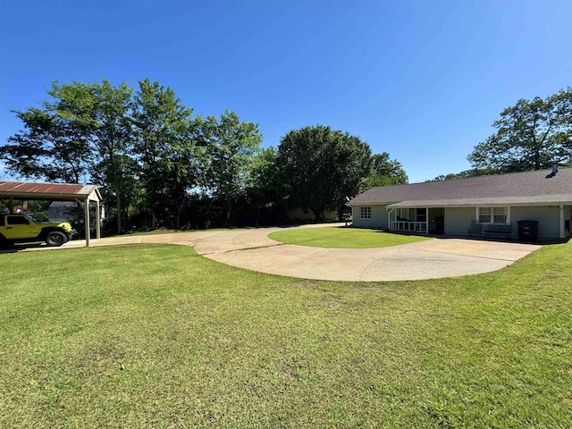  - view of grassy yard with a carport