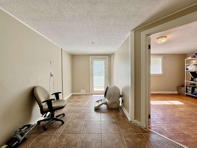  - sitting room with a textured ceiling, healthy amount of natural light, and baseboards