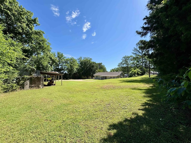  - view of green lawn featuring a carport