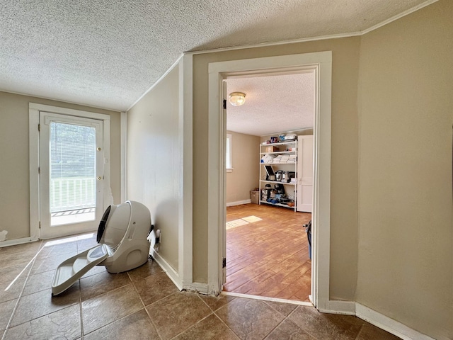  - living area featuring a textured ceiling, baseboards, and ornamental molding