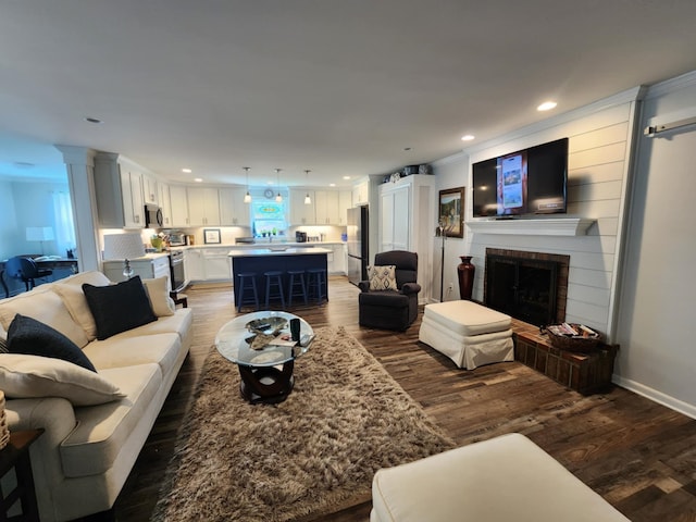living room featuring wood finished floors, a fireplace, recessed lighting, and baseboards