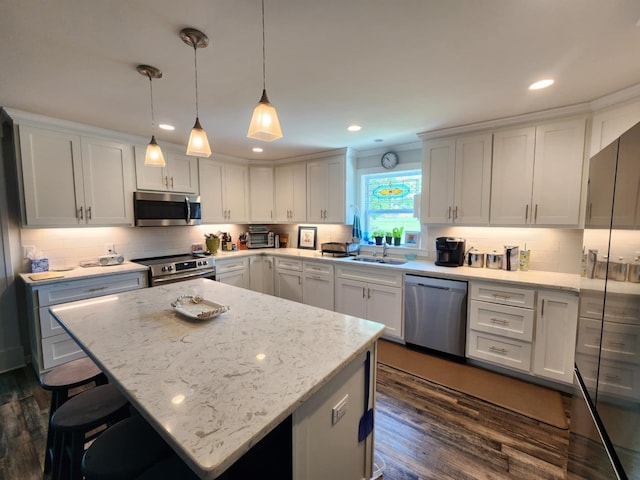 kitchen featuring stainless steel appliances, dark wood-type flooring, tasteful backsplash, a sink, and recessed lighting