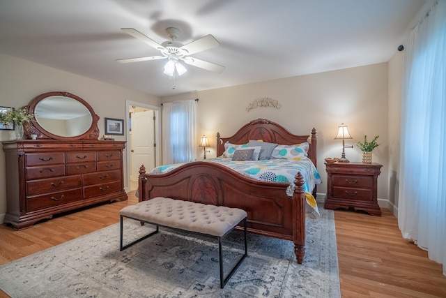 bedroom with baseboards, light wood-style floors, and a ceiling fan
