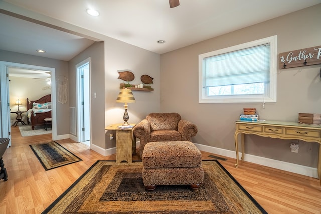 living area with baseboards, visible vents, light wood-style floors, and a ceiling fan