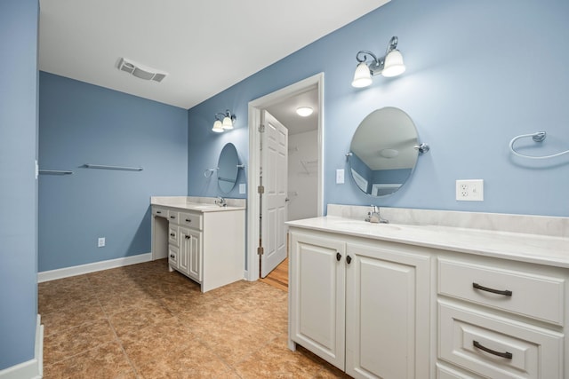 full bathroom featuring two vanities, a sink, visible vents, and baseboards