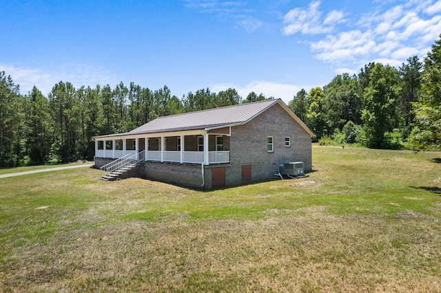 view of home's exterior featuring cooling unit, covered porch, a yard, and metal roof