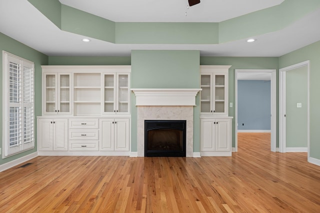 unfurnished living room with a fireplace, recessed lighting, light wood-style floors, a ceiling fan, and baseboards