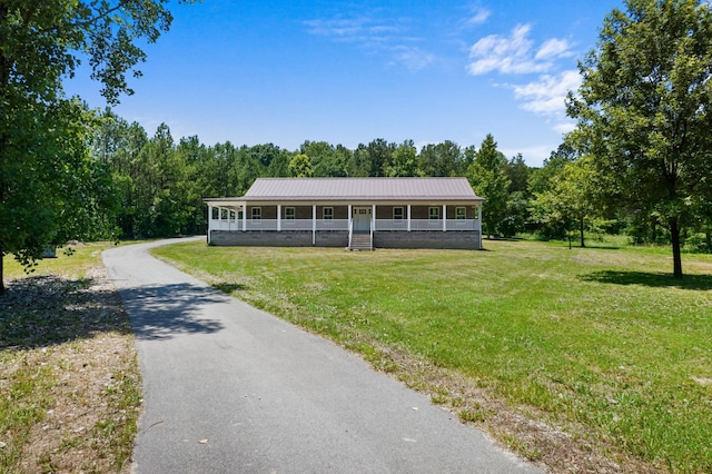 country-style home with covered porch, metal roof, and a front lawn