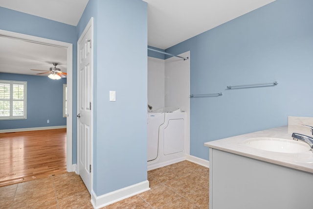 bathroom with baseboards, walk in shower, vanity, and tile patterned floors