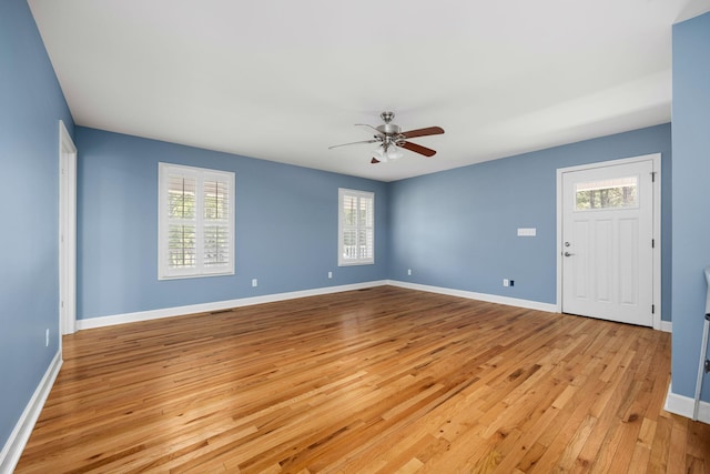 unfurnished room with baseboards, ceiling fan, and light wood finished floors