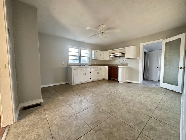 kitchen with ceiling fan, baseboards, visible vents, and white cabinets