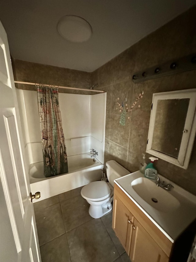 bathroom with tile patterned flooring, toilet, vanity, tile walls, and shower / bath combo