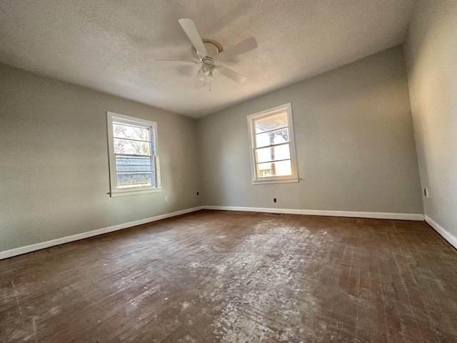 unfurnished room with baseboards, a textured ceiling, a wealth of natural light, and a ceiling fan