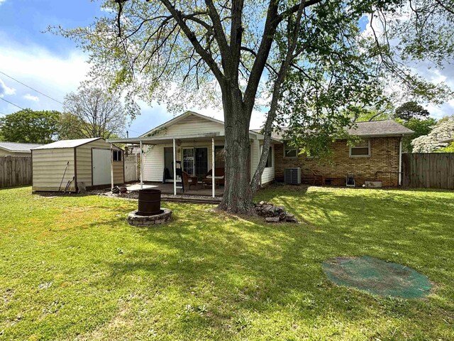 - back of house with central air condition unit, a fire pit, a patio area, and brick siding