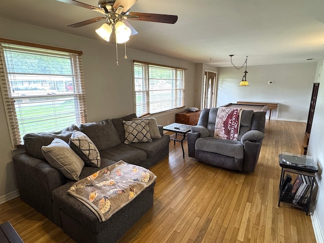  - living room with hardwood / wood-style flooring, plenty of natural light, ceiling fan, and baseboards