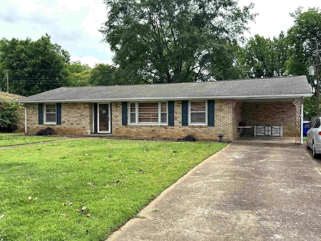  - ranch-style house featuring brick siding, driveway, a front lawn, an attached carport, and roof with shingles