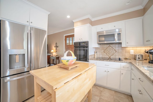 kitchen featuring decorative backsplash, crown molding, white cabinetry, light stone counters, and black appliances