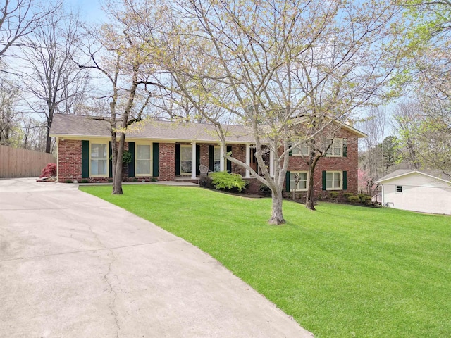 single story home with brick siding, fence, and a front lawn