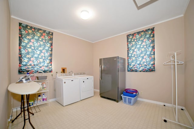 washroom featuring baseboards, washing machine and dryer, laundry area, and ornamental molding