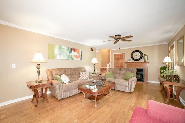 living room featuring baseboards, light wood-type flooring, ceiling fan, and ornamental molding